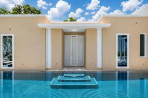 a house with a swimming pool in front of it at Sunshine Beach Villa Mai Khao in Mai Khao Beach +50 photos