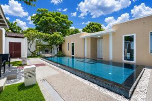 a swimming pool in the backyard of a house at Sunshine Beach Villa Mai Khao in Mai Khao Beach
