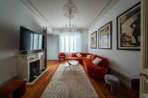 a living room with a red couch and a fireplace at Le Grand Rivage in Verdun-sur-Meuse