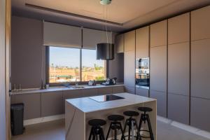 a kitchen with a island with bar stools at TRIANON Résidence Hôteliere in Marrakesh