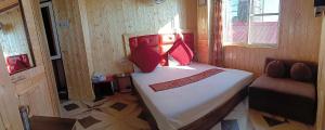 a small bedroom with a bed with red pillows at HOTEL MALOOK A blink away from Mall Road in Shimla +18 photos