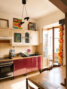 a kitchen with a red cabinets and a table at Chez Brigitte Guesthouse in Nice