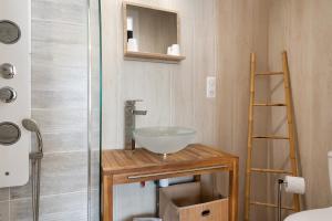a bathroom with a bowl sink on a wooden table at Chambres d'Emilie - Table d'Hôte in Lau-Balagnas +38 photos