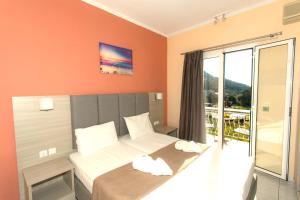 a hotel room with a bed and a balcony at Oliva Resort View & Swimming pool Studios in Parga