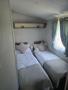 a group of three beds in a small room at 51 Denbigh 8 berth static caravan in Prestatyn