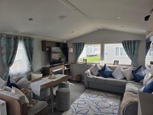 a living room with a couch and a table at 51 Denbigh 8 berth static caravan in Prestatyn