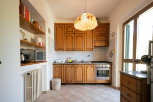 a kitchen with wooden cabinets and a chandelier at Casa Natalina in Montecatini Terme