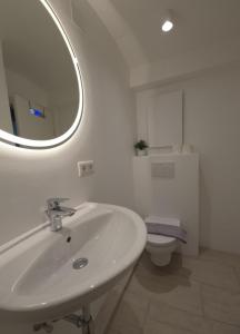 a white bathroom with a sink and a toilet at Ferienwohnung Holiday Lienz in Lienz +21 photos