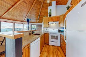 a kitchen with wooden cabinets and a white refrigerator at Whidbey Moon Landing in Coupeville