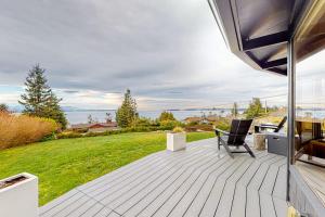a patio with a table and chairs and a view of the ocean at Whidbey Moon Landing in Coupeville