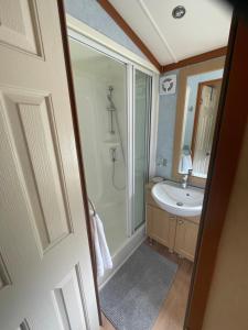 a bathroom with a shower and a sink at 38 the pines in Newton on the Moor +13 photos