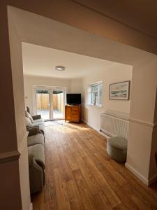 a living room with a couch and a tv at Home in Greatstone in Greatstone