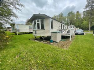 a mobile home with a car parked in a yard at 38 the pines in Newton on the Moor
