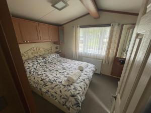 a bedroom with a bed and a window at 38 the pines in Newton on the Moor