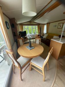 a table and chairs in a room with a living room at 38 the pines in Newton on the Moor