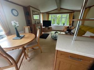 a kitchen and living room with a table and chairs at 38 the pines in Newton on the Moor