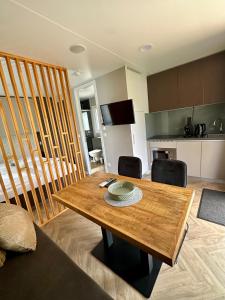 a living room with a wooden table and a kitchen at EuroParcs Ossiacher See in Ossiach