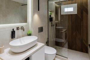 a bathroom with a white sink and a shower at Ciel Collection - Luxury Seafront Living in Perea +51 photos