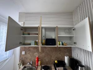 a kitchen with white cabinets and a sink at Studio apartment - Park view - for 2 guests in Thun