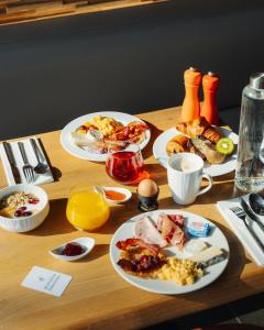 a table with plates of breakfast food on it at Domaine de Dolomieu Hotel & Spa - BW Premier Collection in Dolomieux