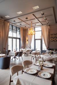 a restaurant with tables and chairs and a chandelier at City Park Hotel in Chişinău