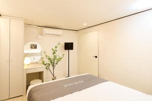 ein kleines Schlafzimmer mit Bett und Schreibtisch in der Unterkunft AvIENNE 홍대 명동 이태원 DDP KSPO 경북궁 롯데월드 성수 in Seoul