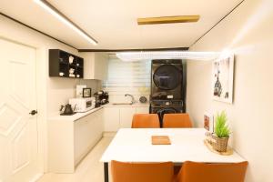 eine Küche und ein Esszimmer mit Tisch und Stühlen in der Unterkunft AvIENNE 홍대 명동 이태원 DDP KSPO 경북궁 롯데월드 성수 in Seoul