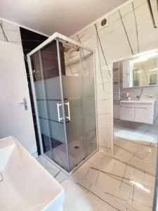 a bathroom with a glass shower and a sink at Hotel Art Balkanhof in Gelsenkirchen
