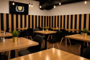 a restaurant with wooden tables and chairs and a black and white striped wall at B&B Gdynia in Gdynia +15 photos