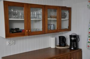 a kitchen counter with wooden cabinets and a coffee maker at Kaszuby Stężyca holiday cottage in Stężyca +3 photos