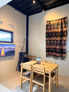 a table and chairs in a room with a curtain on the wall at Uma Pirates Lombok in Mataram