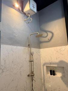 a shower in a bathroom with a light on the wall at Uma Pirates Lombok in Mataram +30 photos