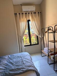 a bedroom with a bed and a window at Uma Pirates Lombok in Mataram