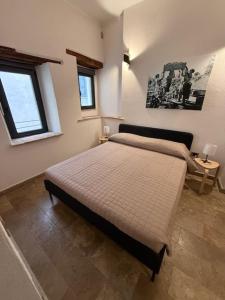 a bedroom with a bed and two windows at Alla botte degli Orsini in Attigliano
