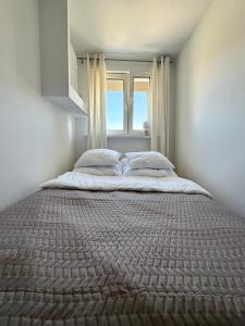 a large bed in a room with a window at Apartament Centrum in Olsztynek