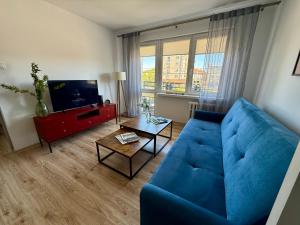 a living room with a blue couch and a tv at Apartament Centrum in Olsztynek