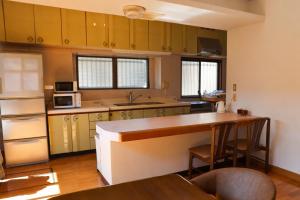 a kitchen with yellow cabinets and a table in it at Island Base Shimami in Nobeoka +30 photos