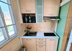 a small kitchen with a sink in a tiny house at Cozy Minimal 1BR CMBD Pool Long Stay Friendly in Phra Khanong