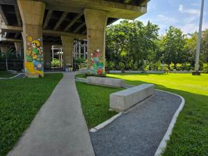 a park with a bench next to a building at Cozy Minimal 1BR CMBD Pool Long Stay Friendly in Phra Khanong