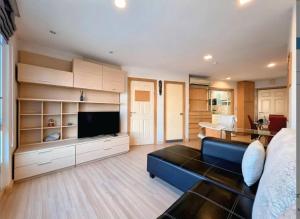 a living room with a blue couch and a television at Cozy Minimal 1BR CMBD Pool Long Stay Friendly in Phra Khanong