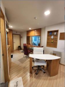 a room with a table and chairs and a kitchen at Cozy Minimal 1BR CMBD Pool Long Stay Friendly in Phra Khanong +5 photos