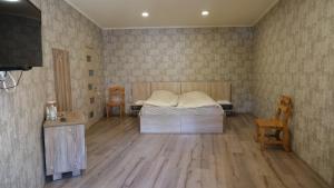 a bedroom with a bed and two chairs and a television at Dilichella Resort in Dilijan