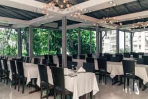 a dining room with white tables and black chairs at Blue Diamond Alya Hotel in Alanya