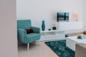 a living room with a blue chair and a tv at Apartment - Casa Andres in Salir de Porto +42 photos