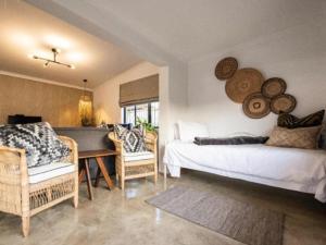 a bedroom with a bed and a table and chairs at Fever Tree Self Catering in Hillcrest