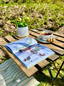 a picnic table with a book and a cup of tea at Nordic Quiet Stay in Falun