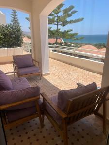 a balcony with two chairs and a view of the ocean at Tigert agadir in Agadir