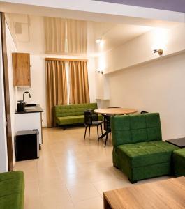 a living room with a table and green chairs at Vernisa Hotel in Tbilisi City