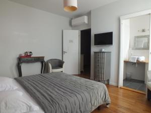 a bedroom with a bed and a desk and a television at A la Fleur de Lys in Langeais