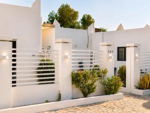 a white house with plants on the facade at Liora Inside Al Dana beach Resort in Half Moon Bay